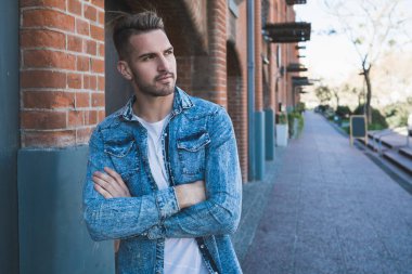 Sokaklarda günlük giysiler giyen yakışıklı bir gencin portresi. Şehir konsepti.