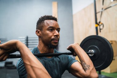 Halterle egzersiz yapan genç çapraz formda sporcunun portresi. Crossfit, spor ve sağlıklı yaşam tarzı konsepti.