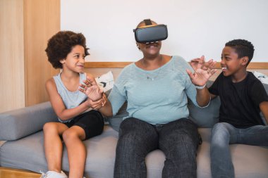 Evde VR gözlükleriyle oynayan Afrikalı Amerikalı büyükanne ve torunların portresi. Aile ve teknoloji kavramı.