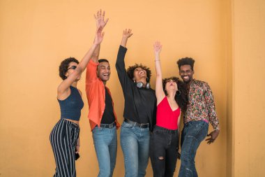 Afro arkadaşlarının portresi sarı arka planda bir şeyleri kutlarken birlikte eğleniyor ve eğleniyorlar. Arkadaşlık, başarı ve yaşam tarzı konsepti.