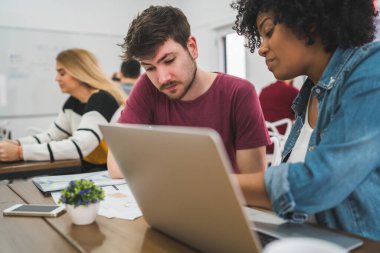 Genç yaratıcı tasarımcılar bir projede çalışıyor ve işyerindeki yeni düzen gelişimini tartışıyorlar. İş konsepti.
