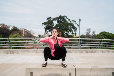 Parkta egzersiz yapan atletik bir kadının portresi. Spor ve sağlıklı yaşam tarzı kavramı.