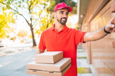 Kartondan pizza kutusu çalan bir teslimatçının portresi. Teslimat ve nakliye hizmeti kavramı.