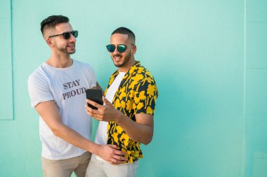 Cep telefonu kullanırken birlikte zaman geçiren mutlu eşcinsel çiftin portresi. Lgbt ve Aşk Konsepti.