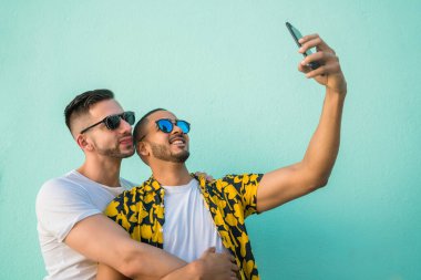 Mutlu eşcinsel çiftin portresi. Birlikte zaman geçirip cep telefonuyla selfie çekiyorlar. Lgbt ve Aşk Konsepti.