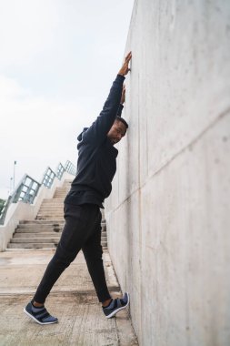 Açık havada egzersiz yapmadan önce bacaklarını esneten bir sporcunun portresi. Spor ve sağlıklı yaşam tarzı.