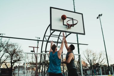 Genç basketbolcular dışarıda teke tek oynuyor. Spor ve basketbol konsepti.