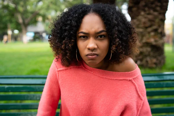 一个年轻美丽的非洲裔美国女人的画像 她满脸怒容坐在公园的长椅上 — 图库照片