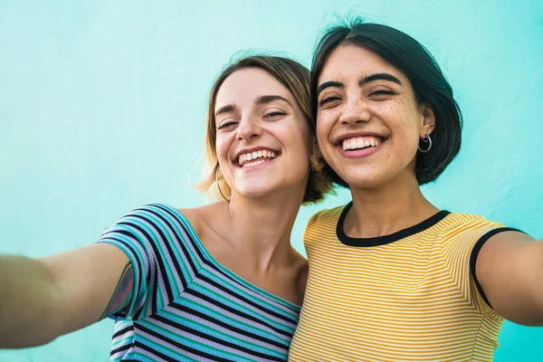 Retrato Lindo Casal Lésbico Divertindo Tirando Uma Selfie Contra Fundo — Fotografia de Stock