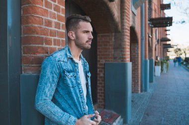 Sokaklarda günlük giysiler giyen yakışıklı bir gencin portresi. Şehir konsepti.