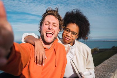 İki genç arkadaşın portresi. Birlikte iyi vakit geçiriyorlar ve dışarıda selfie çekiyorlar..