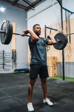 Halterle egzersiz yapan genç çapraz formda sporcunun portresi. Crossfit, spor ve sağlıklı yaşam tarzı konsepti.