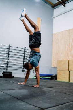 Spor salonunda spor yapan genç bir adamın portresi. Crossfit, spor ve sağlıklı yaşam tarzı konsepti.