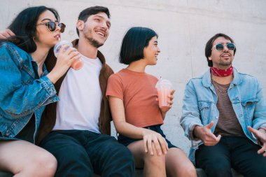 Birlikte eğlenen ve taze meyve suyu içerken eğlenen bir grup arkadaşın portresi. Yaşam tarzı ve arkadaşlık kavramı.