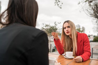 İki kızgın arkadaşın portresi, kahve dükkanında oturup tartışırken ciddi bir konuşma yapıyor. Arkadaşlık kavramı.