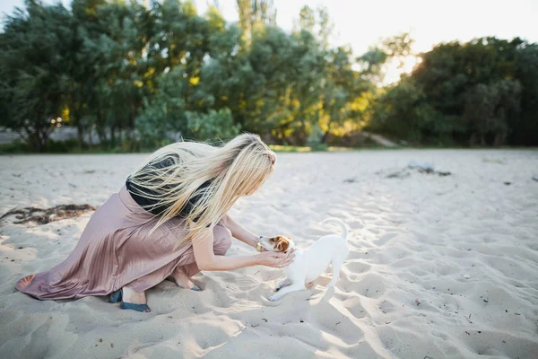 Dívka si hraje s psa na pláži — Stock fotografie