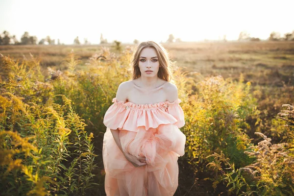 Молодая девушка в персиковом платье — стоковое фото