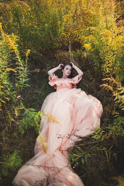 Молодая девушка в персиковом платье — стоковое фото