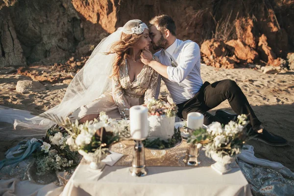 Noivo beijando noiva na mesa de ajuste — Fotografia de Stock