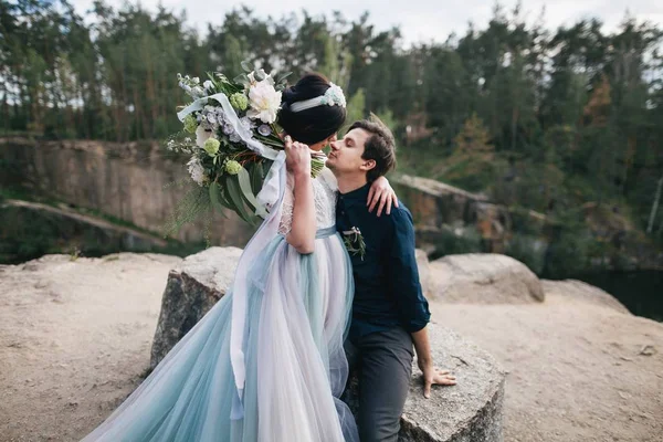 Unga lyckliga brudparet på klippa — Stockfoto