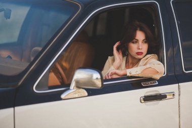 Eski model araba içindeki genç kız