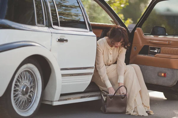 woman sitting in vintage car