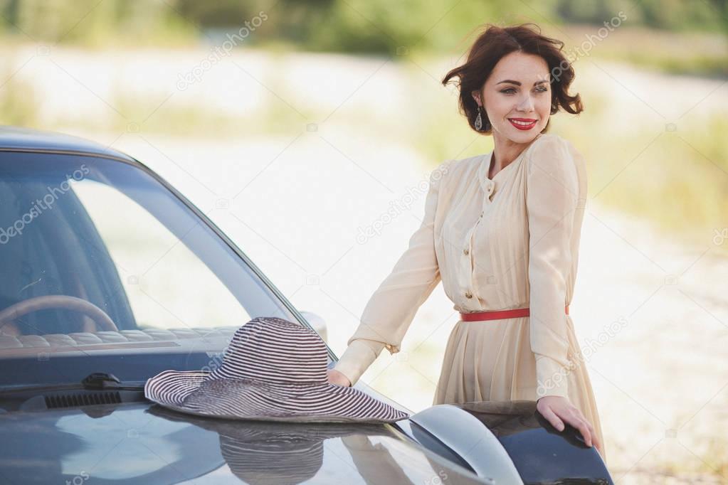 woman posing near vintage car