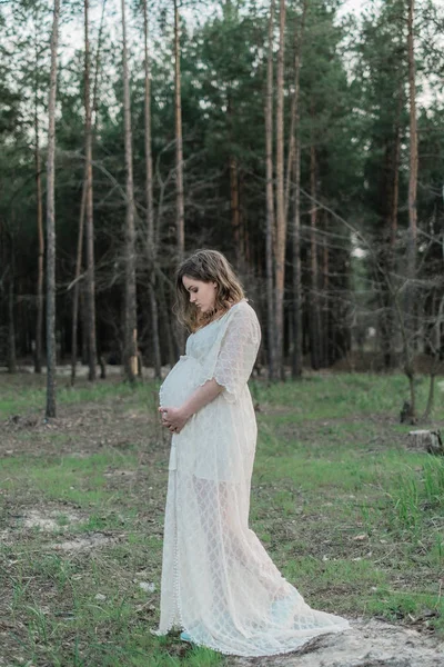 Mulher grávida no gramado na floresta — Fotografia de Stock