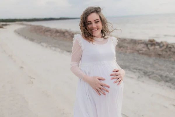 Těhotná žena na břehu jezera — Stock fotografie