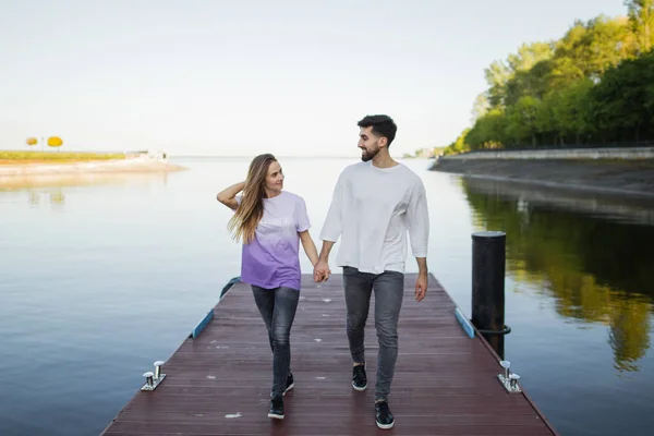 Pareja en muelle en el lago — Foto de Stock