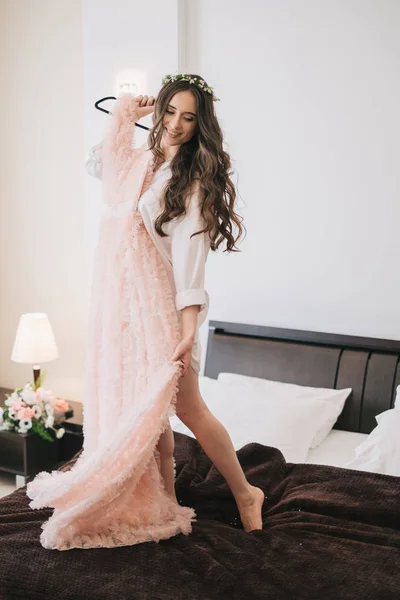 Kvinna med klänning stående på säng — Stockfoto