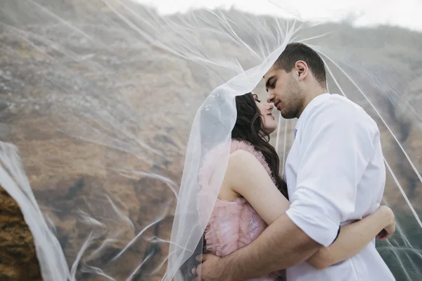 Pareja besándose bajo velo — Foto de Stock