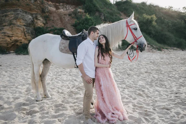 Young loving couple with white horse — Stock fotografie