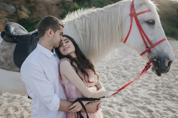 Young loving couple with white horse — Stock Photo, Image