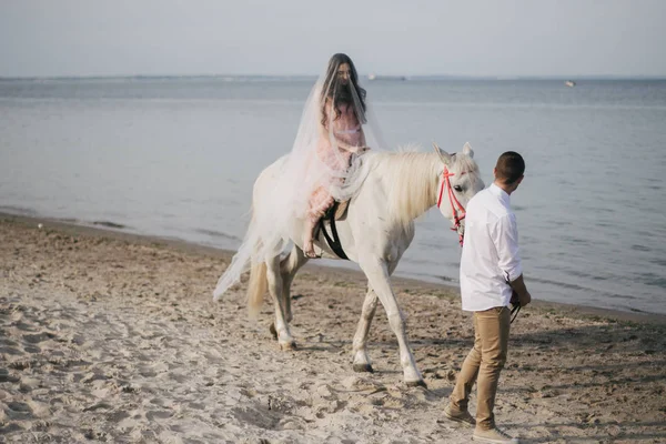 Brudgummen med bruden på häst — Stockfoto