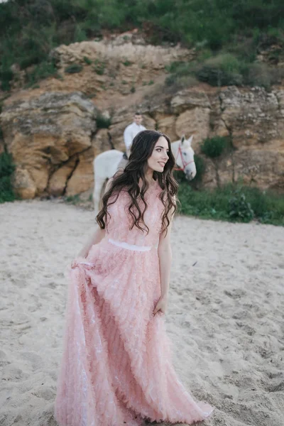 Jong meisje in perzik jurk op strand — Stockfoto