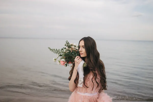 Girl with bouquet, alfresco on beach — Stock Photo, Image