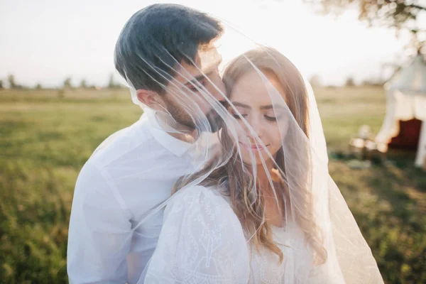 Pareja joven bajo velo blanco —  Fotos de Stock