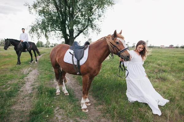 Couple with horses in countryside — Stock Photo, Image
