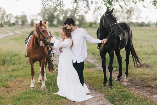 Couple walk with horses — Stock Photo, Image