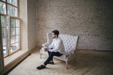 Beyaz vintage koltukta oturan adam