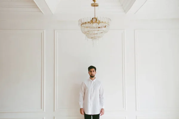 Mannen i vitt rum med kristallkrona — Stockfoto