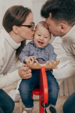 Genç çift midilli sallanan üzerinde erkek bebek öpüşme portresi kırpılmış