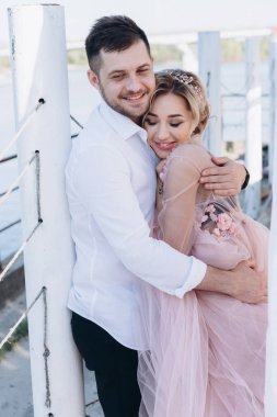 nehir kıyısında çift korkuluk yakınındaki sarılma portresi 