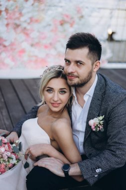 Gelin ve damat ahşap güverte üzerinde oturan gündüz portresi