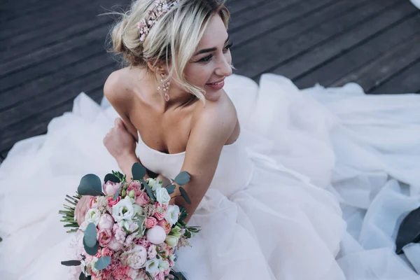 çiçeklerle oturan ve bir kenara seyir gelinlik genç kadın portresi kırpılmış