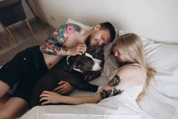 Vrolijke Paar Omhelst Hond Bed Thuis — Stockfoto