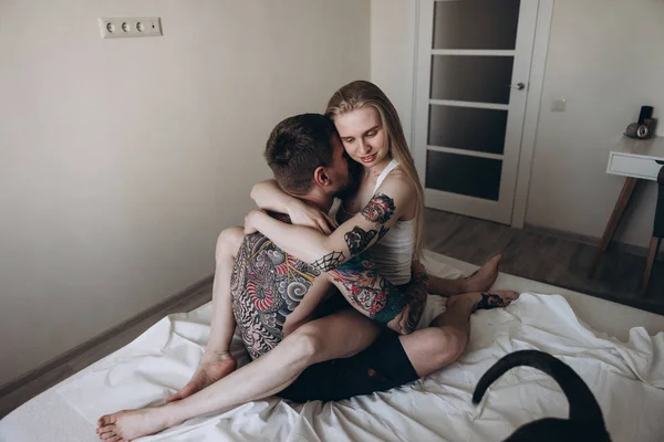 Şehvetli dövmeli çift evde yatakta kucaklayan