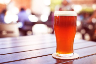 Bira bahçesindeki ahşap masada yarım litre bira.