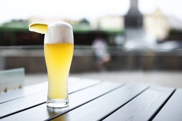Glass of wheat beer with slice of lemon on a table outdoors in Minsk, Belarus